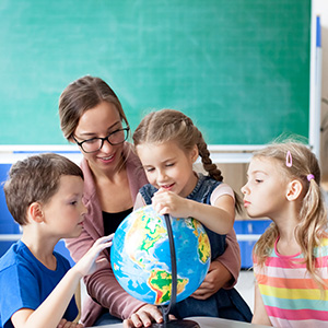 students and teacher studying a globe